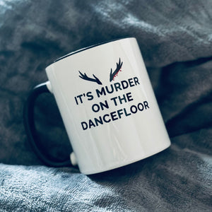 Mug with a black handle and black inner that reads "It's Murder On The Dancefloor" with antlers above the text with blood drips coming from the right bottom antler