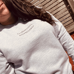 Sweatshirt that has "Professional Overthinker" in typewriter style font