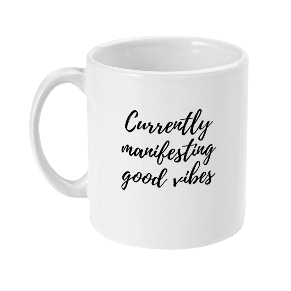 Mug that has "currently manifesting good vibes" in script like font