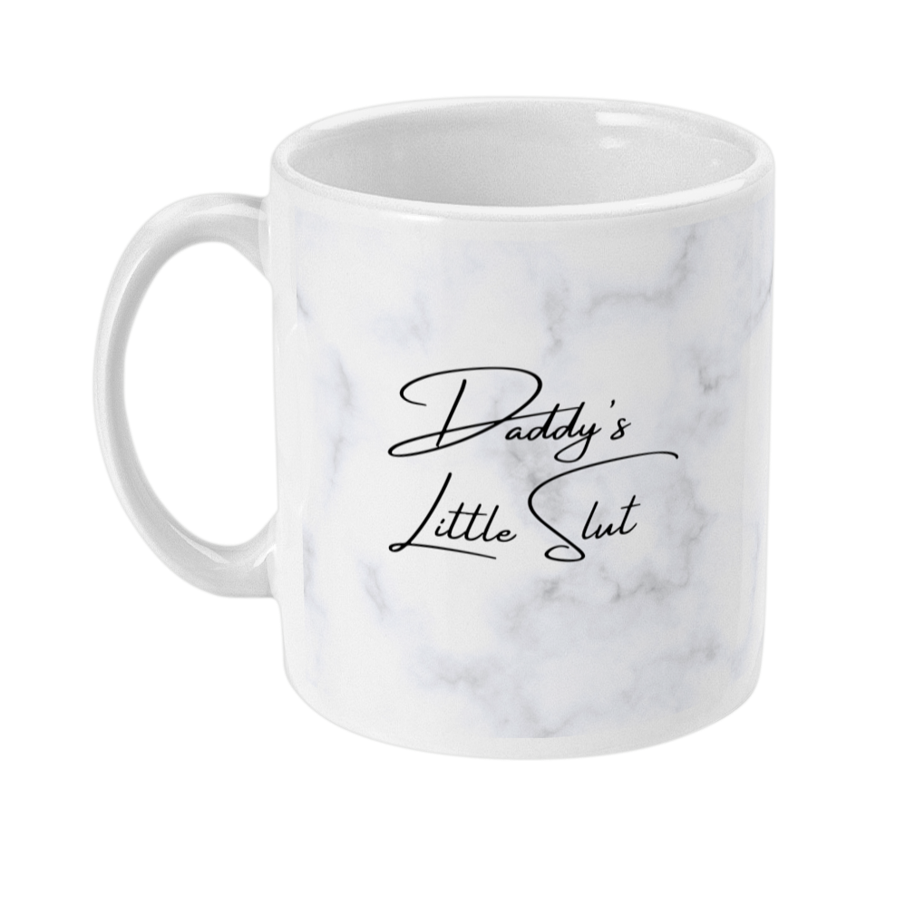 Mug with text on that says Daddy's Little Slut with a light marble print on the background