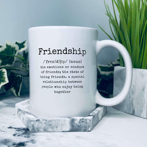 Mug reads Friendship /ˈfrɛn(d)ʃɪp/ [noun] the emotions or conduct of friends; the state of being friends. a special relationship between people who enjoy being together