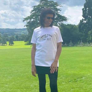 Arctic white organic t-shirt that reads good vibes all the way. The positive affirmation club. Good vibes all the way is in larger text with good vibes arched over the text that then reads all the way. The positive affirmation club text is in a small text that sits underneath good vibes all the way.