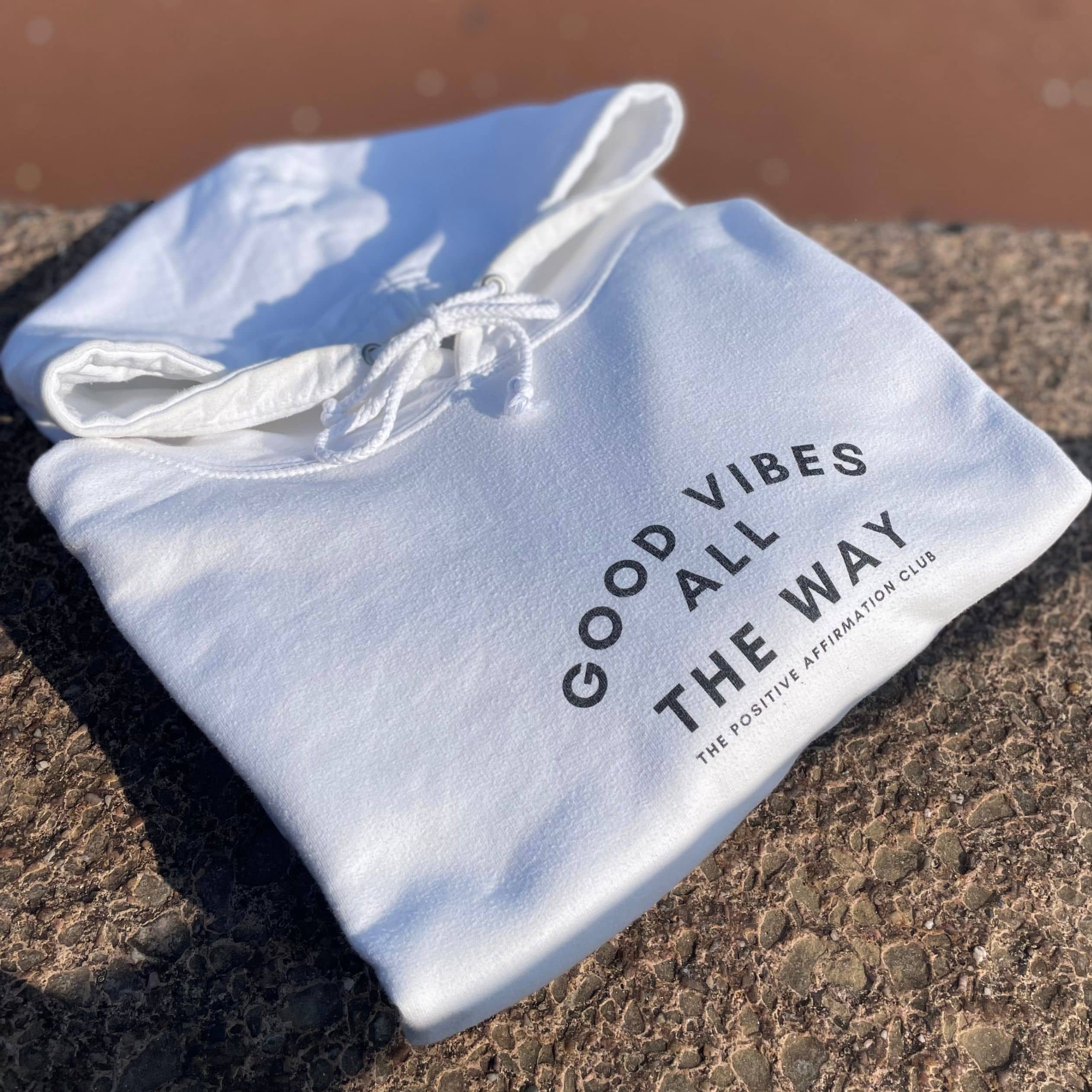 Arctic white hoodie with text that reads: Good Vibes All The Way. The Positive Affirmation Club in the middle of the chest. Text is in black writing 