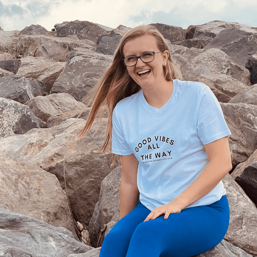 White Organic t-shirt that reads good vibes all the way. the positive affirmation club hoody. Hoody that says Good Vibes All The Way. The Positive Affirmation Club. Good Vibes text is curved with alll directly under the middle of good vibes. The way is the directly under that text. In smaller text it then says The positive affirmation club.