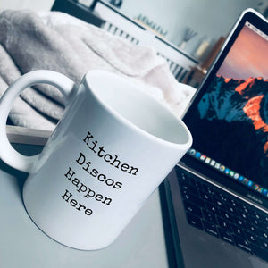 Mug with text on in type writer font that says: Kitchen discos happen here