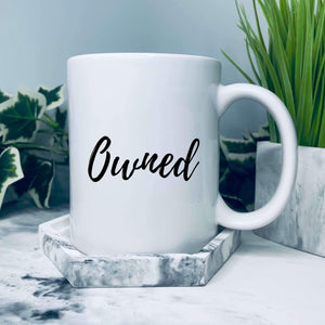Mug with text on in a script style that says: Owned