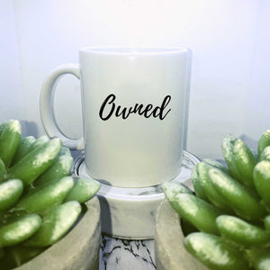 Mug with text on in a script style that says: Owned