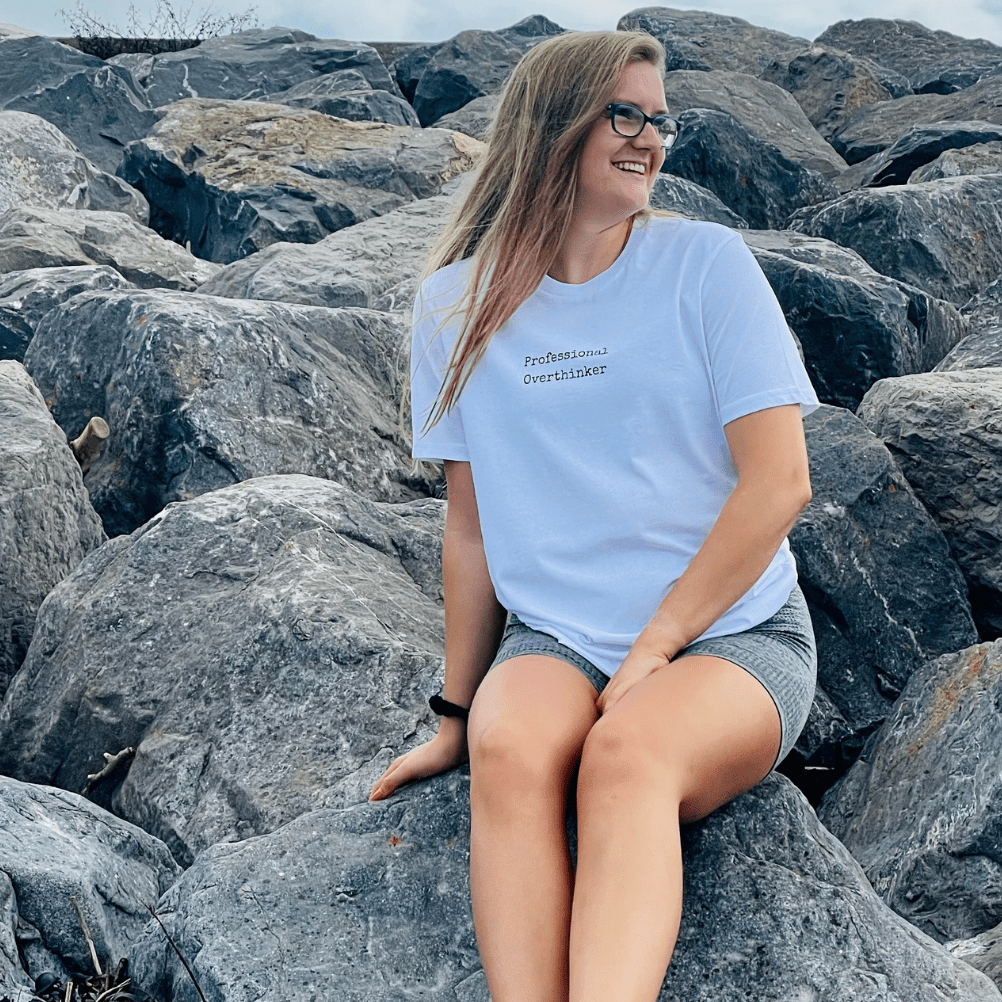 Arctic White Organic T-Shirt that reads professional overthinker in a typewriter style font. Professional Thinker takes up the middle section of the chest and is a small style size to not take up to much of the t-shirt