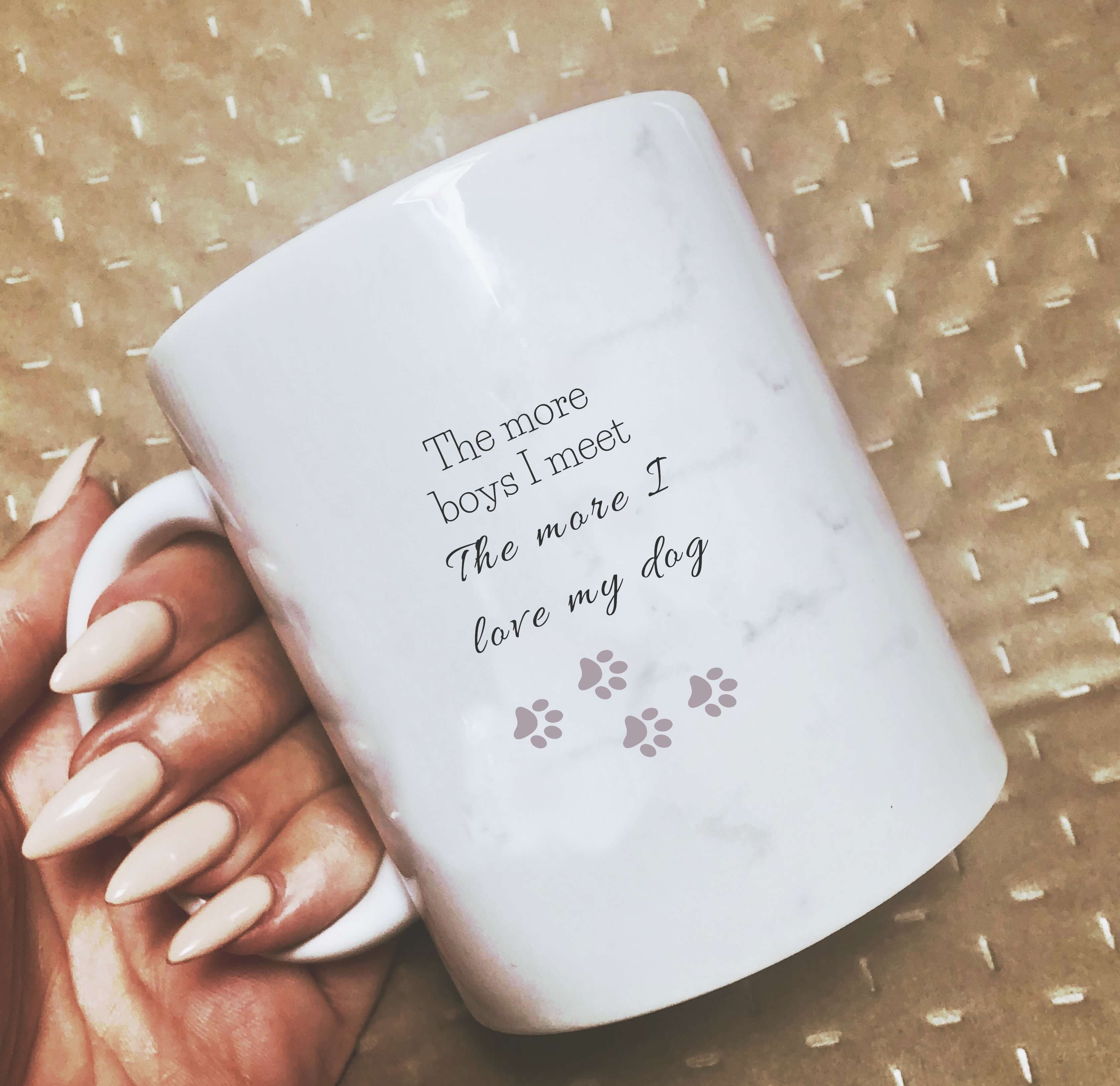 Mug with a light marble print, that says: The more boys I meet, the more I love my dog. With 4 small paw prints underneath