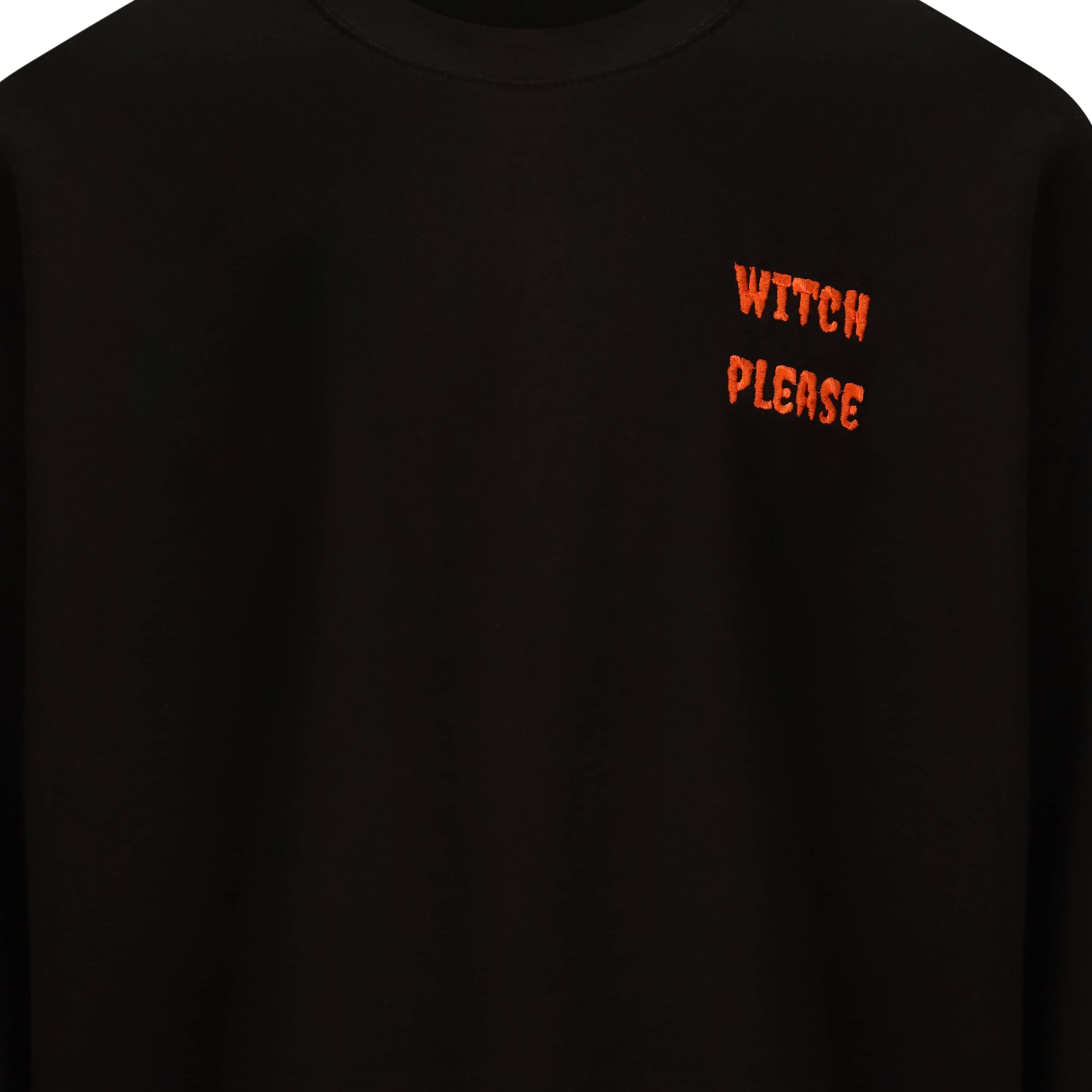 Jet black jumper with pumpkin orange embroidery that reads witch please on the left hand side of the chest. Witch please is written in a halloween creepy style text and is in all caps